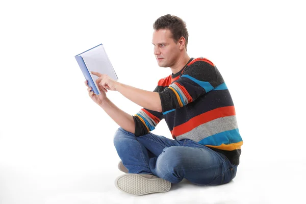 Young man reading a book on the floor isolated — Stock Photo, Image