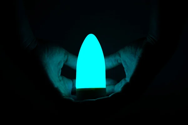 黒の背景に手セキュリティ明るい電球 — ストック写真