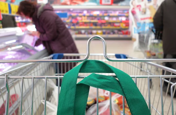 Žena v supermarketu s vozíkem — Stock fotografie