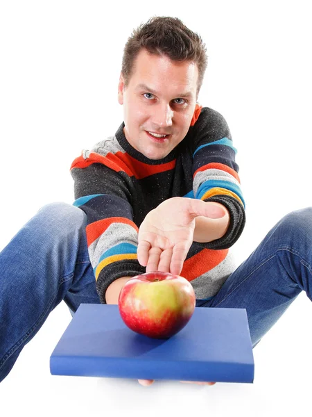 Hombre sosteniendo un libro y una manzana roja — Foto de Stock