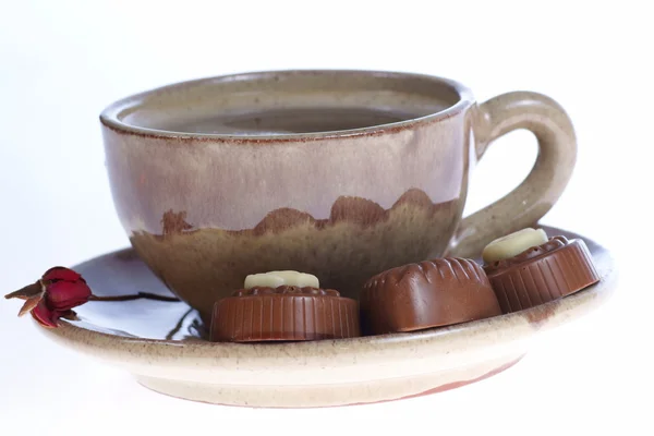 Tazza di praline al cioccolato con caffè nero su bianco — Foto Stock