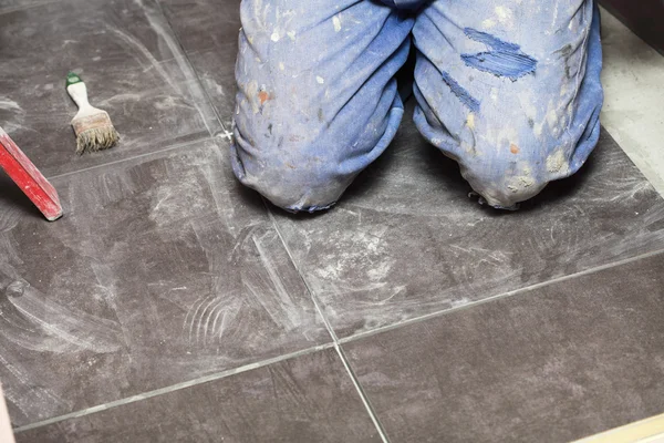 Trabalhador da construção é azulejos em casa azulejo piso adesivo — Fotografia de Stock