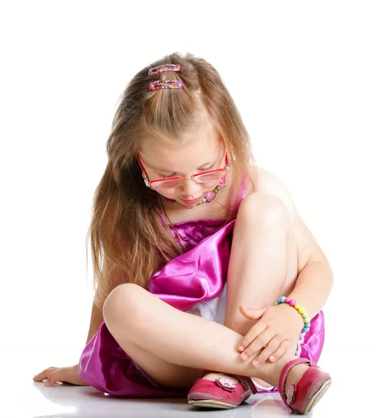 Lindo niña gafas sentado en piso aislado — Foto de Stock