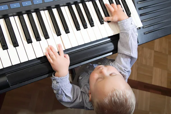 小男孩玩钢琴室内 — 图库照片