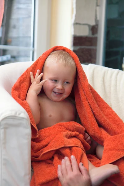 Adorable happy baby boy in orange towel — Stock Photo, Image