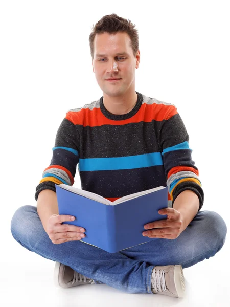 Mladý muž, čtení knihy na podlaze, izolované — Stock fotografie