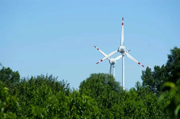 Větrná energie turbína, lesní - modrá obloha — Stock fotografie