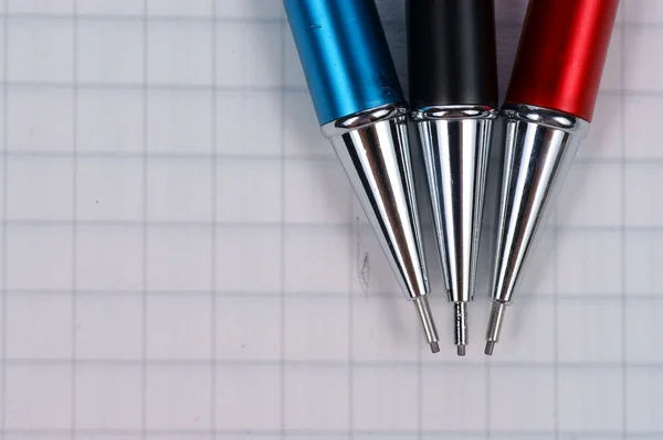 Lege pagina van notebook en zwarte, rode, blauwe potlood — Stockfoto