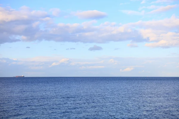 Céu azul nublado partindo para o horizonte mar de superfície azul — Fotografia de Stock