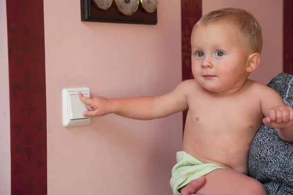 Interested little boy turning off the light-switch — Stock Photo, Image