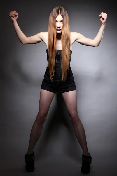 Długie włosy makijaż kobieta pokazuje jej mięśnie — Zdjęcie stockowe