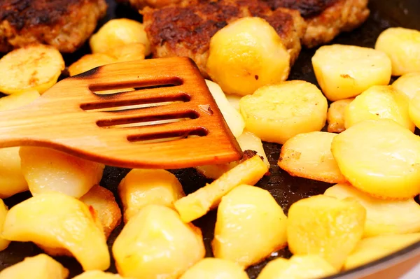 Kořeněné bramborové plátky v pánvi pánev v kuchyni — Stock fotografie