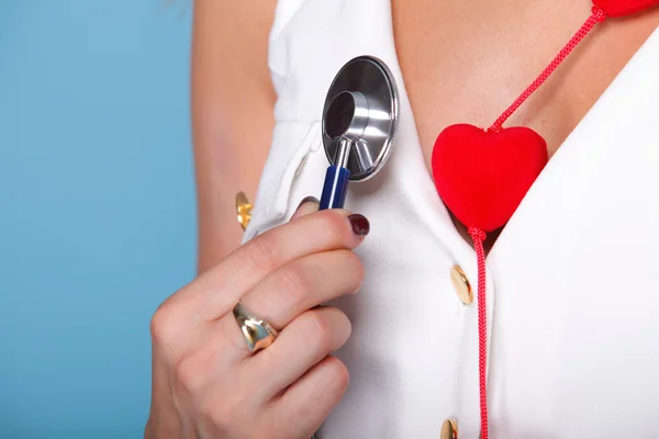 Mujer en traje de enfermera con estetoscopio corazón rojo — Foto de Stock