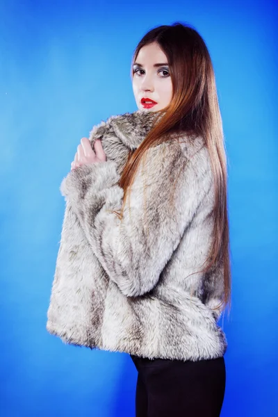 Portrait of young woman in fur blue background — Stock Photo, Image