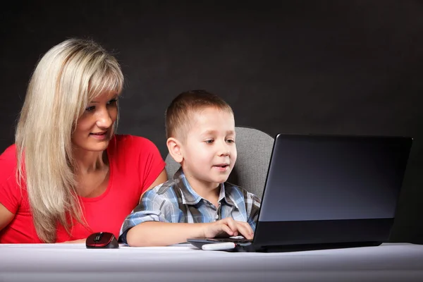 Moeder met zoon op zoek op de laptop — Stockfoto