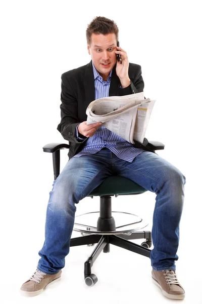 Man kijkt verbaasd tijdens het lezen van een krant — Stockfoto