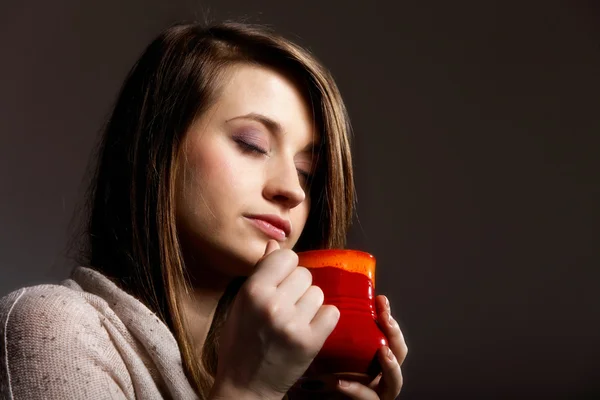 Pretty woman daydreaming while holding a tee cup — Stock Photo, Image