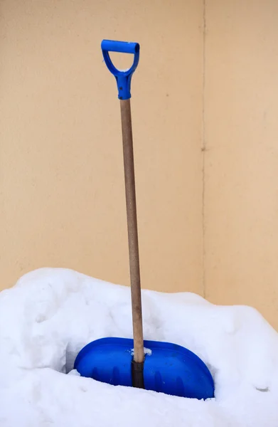 Blue snow shovel standing up in deep snow — Stock Photo, Image