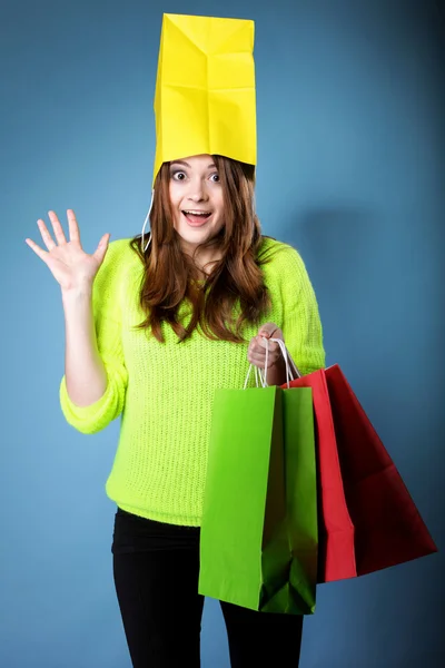 Verrast meisje papier boodschappentas op hoofd. verkoop. — Stockfoto