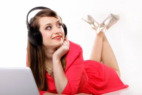 Cute girl with headphones and laptop lying — Stock Photo, Image