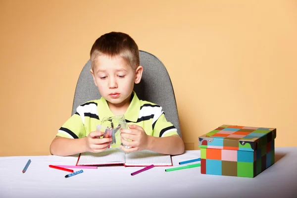 Young cute boy draws with color pencils Stock Picture