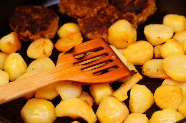 Gekruide aardappel segmenten in koekepan pan in keuken — Stockfoto