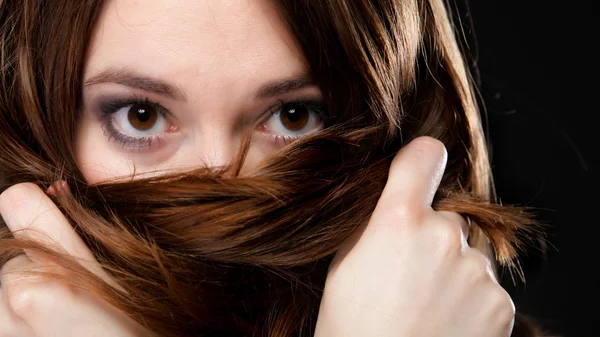 Nahaufnahme Frau bedeckt das Gesicht durch lange braune Haare — Stockfoto