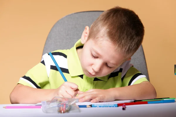 Young cute boy draws with color pencils Royalty Free Stock Photos