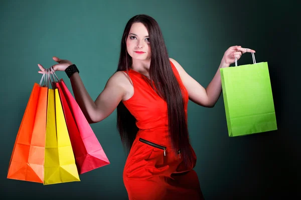 Jonge vrouw met papieren veelkleurige boodschappentas — Stockfoto