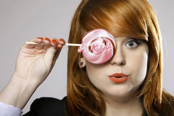 Felice donna dai capelli rossi con caramelle lecca lecca — Foto Stock