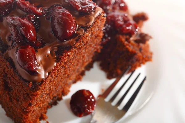 Piece of chocolate cake with icing and cherry — Stock Photo, Image