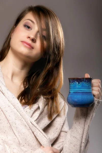 Mujer bonita soñando despierto mientras sostiene una taza de té — Foto de Stock