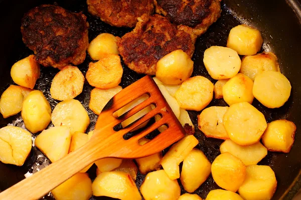 Gekruide aardappel segmenten in koekepan pan in keuken — Stockfoto