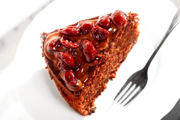 Piece of chocolate cake with icing and cherry — Stock Photo, Image