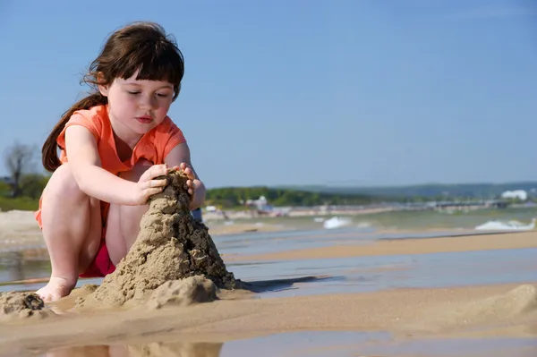 女孩在沙滩上使沙堡 — 图库照片