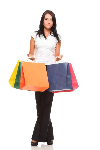 Portrait of young woman carrying shopping bags against white bac — Stock Photo, Image