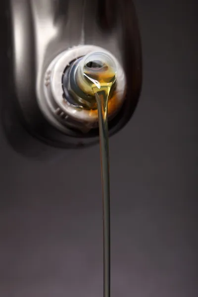 Dose mit Automotor Öl gießt schwarzen Hintergrund — Stockfoto