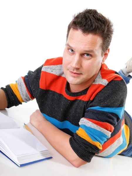 Young man reading a book on the floor isolated — Stock Photo, Image