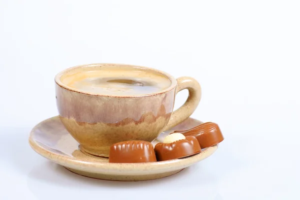 Tazza di praline al cioccolato con caffè nero su bianco — Foto Stock