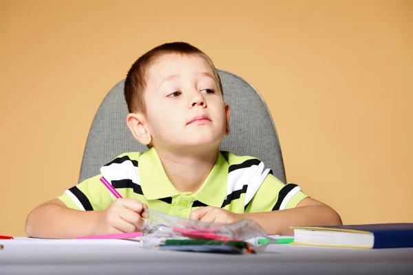 Young cute boy draws with color pencils Stock Photo