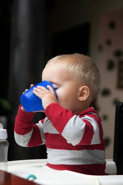 Bambino ragazzo giocare con bottiglia e tazza al coperto — Foto Stock