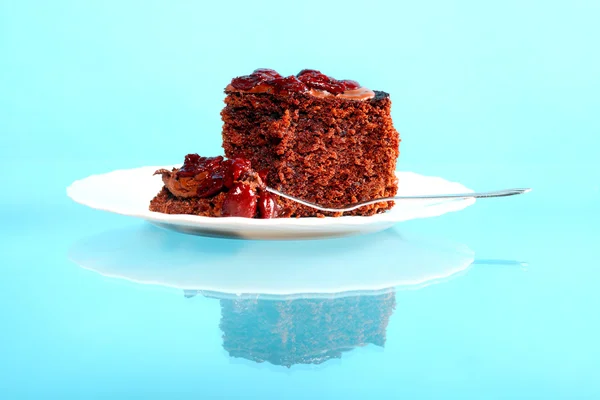 Piece of chocolate cake with icing and cherry — Stock Photo, Image