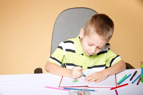 Jeune garçon mignon dessine avec des crayons de couleur — Photo