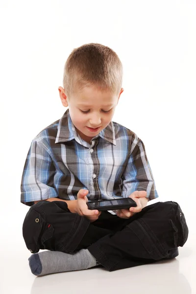 子供は携帯電話でゲームを果たしています。 — ストック写真