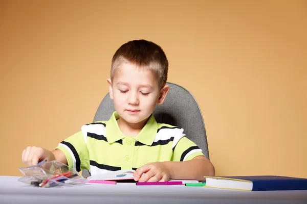 Young cute boy draws with color pencils Stock Picture