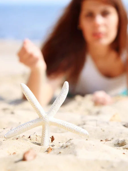 Young woman on seacoast with shell on sand — Stock Photo, Image