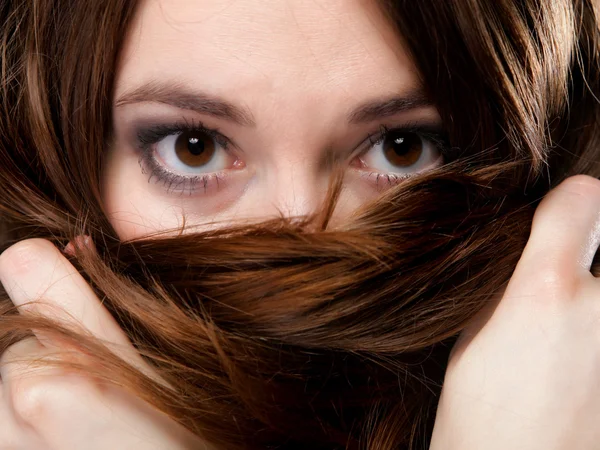 Primeros planos mujer cubre la cara por largos pelos marrones —  Fotos de Stock