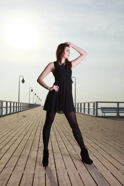 Aantrekkelijke jonge vrouw op de pier — Stockfoto