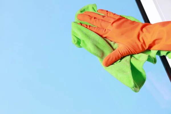 Gloved hand cleaning window with rag — Stock Photo, Image