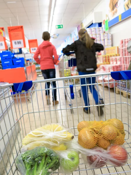 Carrito de compras con comestibles en el supermercado — Foto de Stock